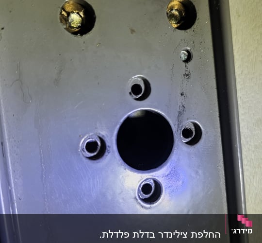 קדחים במנגנון דלת מתכת במהלך החלפת צילינדר או תיקון מנעול